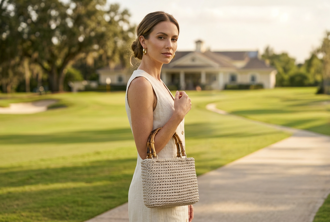Luxury beige woven handbag on a female model, background a golf course.