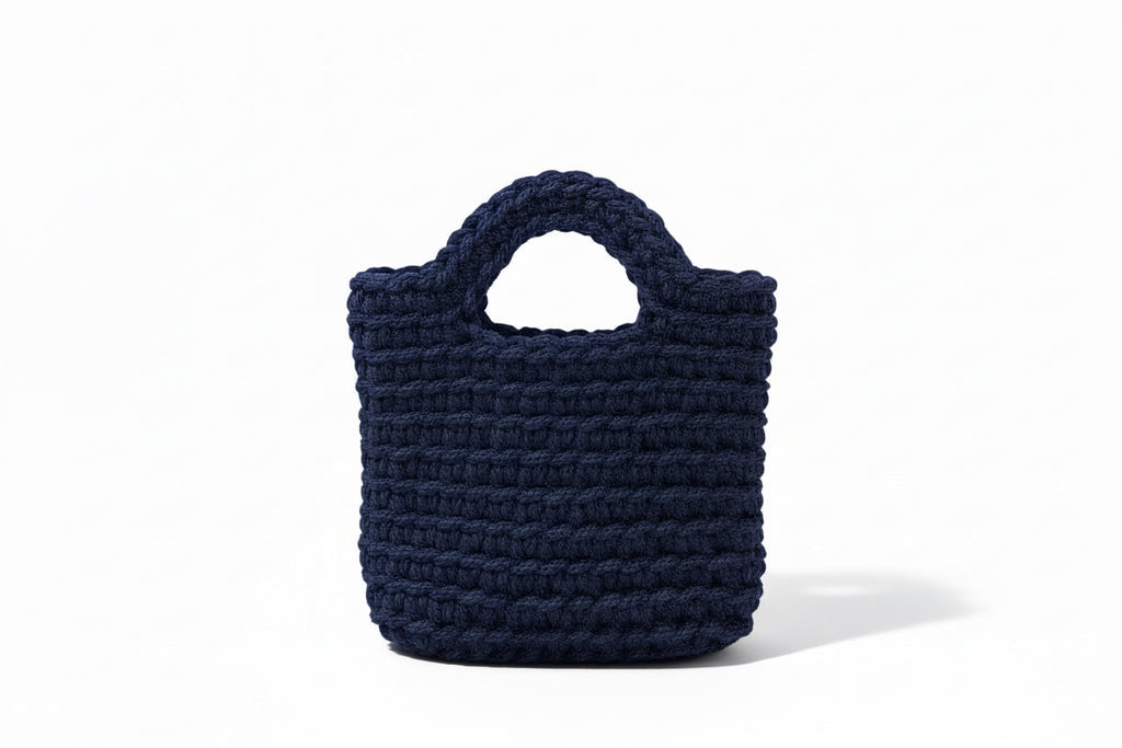 Dark navy woven bag with white background.