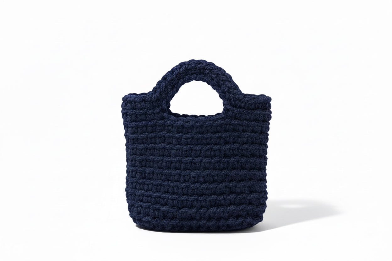 Dark navy woven bag with white background.