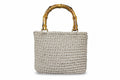 Woven handbag with a bamboo handle on a white background